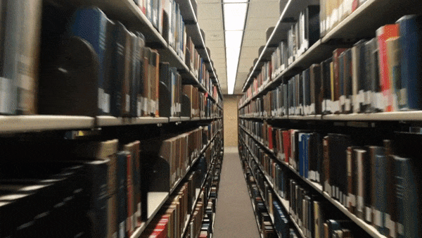 Walking through a narrow hallway in a library